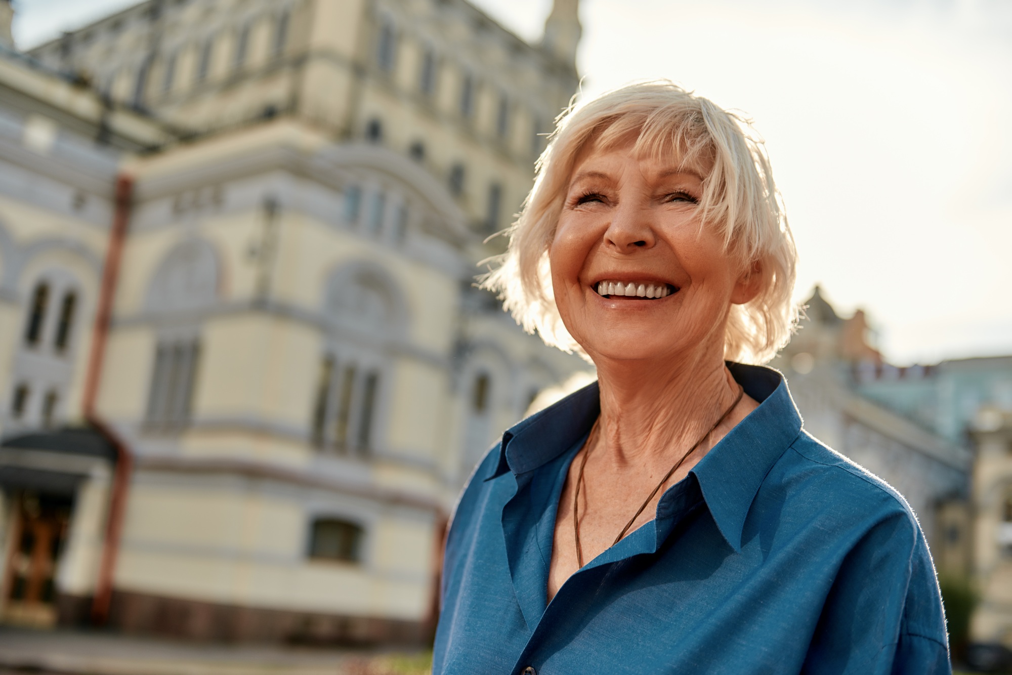Good mood! Portrait of beautiful and happy senior woman smiling while standing outdoors on a sunny Good mood! Portrait of beautiful and happy senior woman smiling while standing outdoors on a sunny